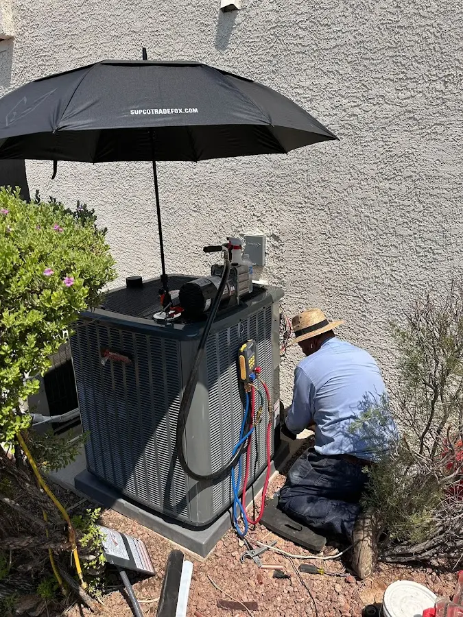 HVAC technician performing outdoor AC maintenance in Glastonbury