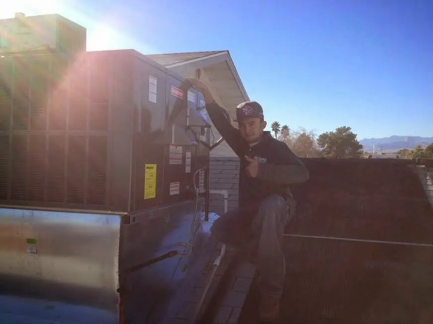 HVAC technician performing HVAC Inspection on a rooftop unit in Glastonbury